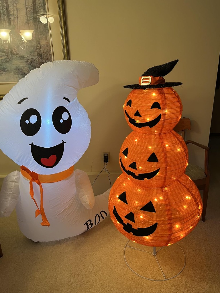 GOOSH ghost displayed indoors next to lighted pumpkin tower