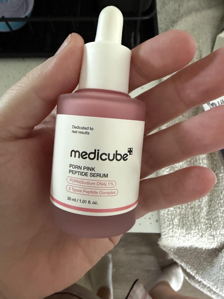 medicube PDRN Pink Peptide Serum Bottle in Hand showing PDRN Sodium DNA 1% and 5 Types Peptide Complex