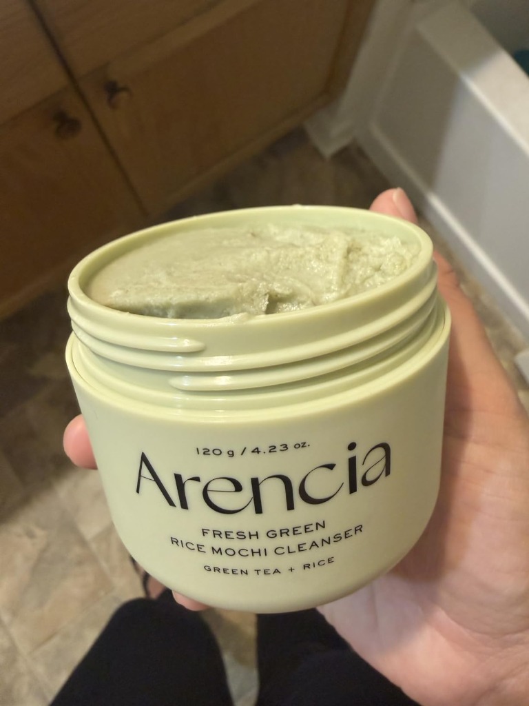 Holding open jar of Arencia Green Rice Cleanser