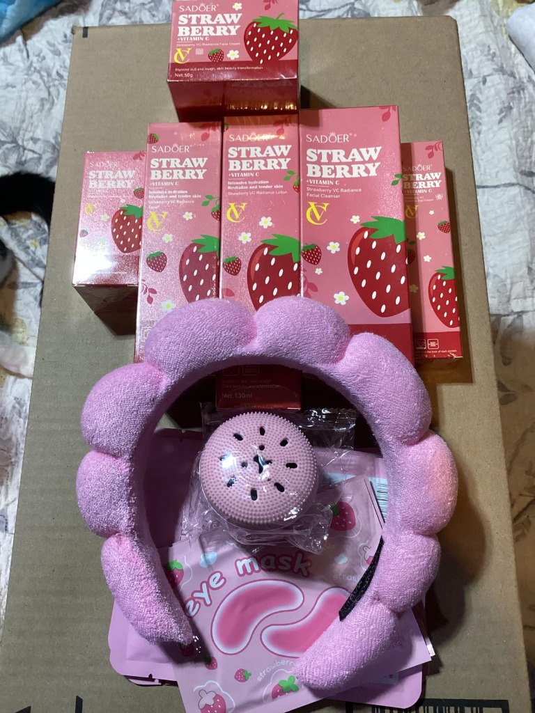SADOER Strawberry Skincare unboxing flatlay showing all boxed bottles, spa headband, and cleansing octopus