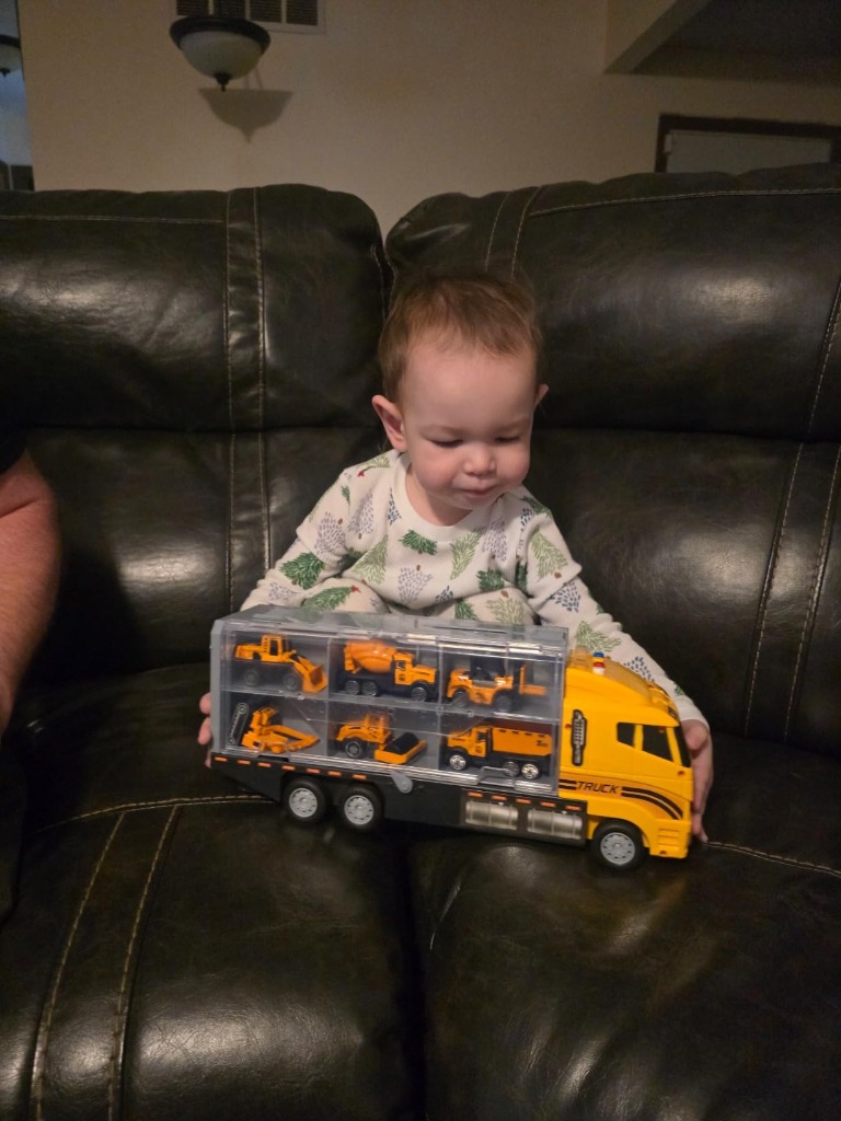 Toddler holding 7-in-1 Construction Carrier Truck